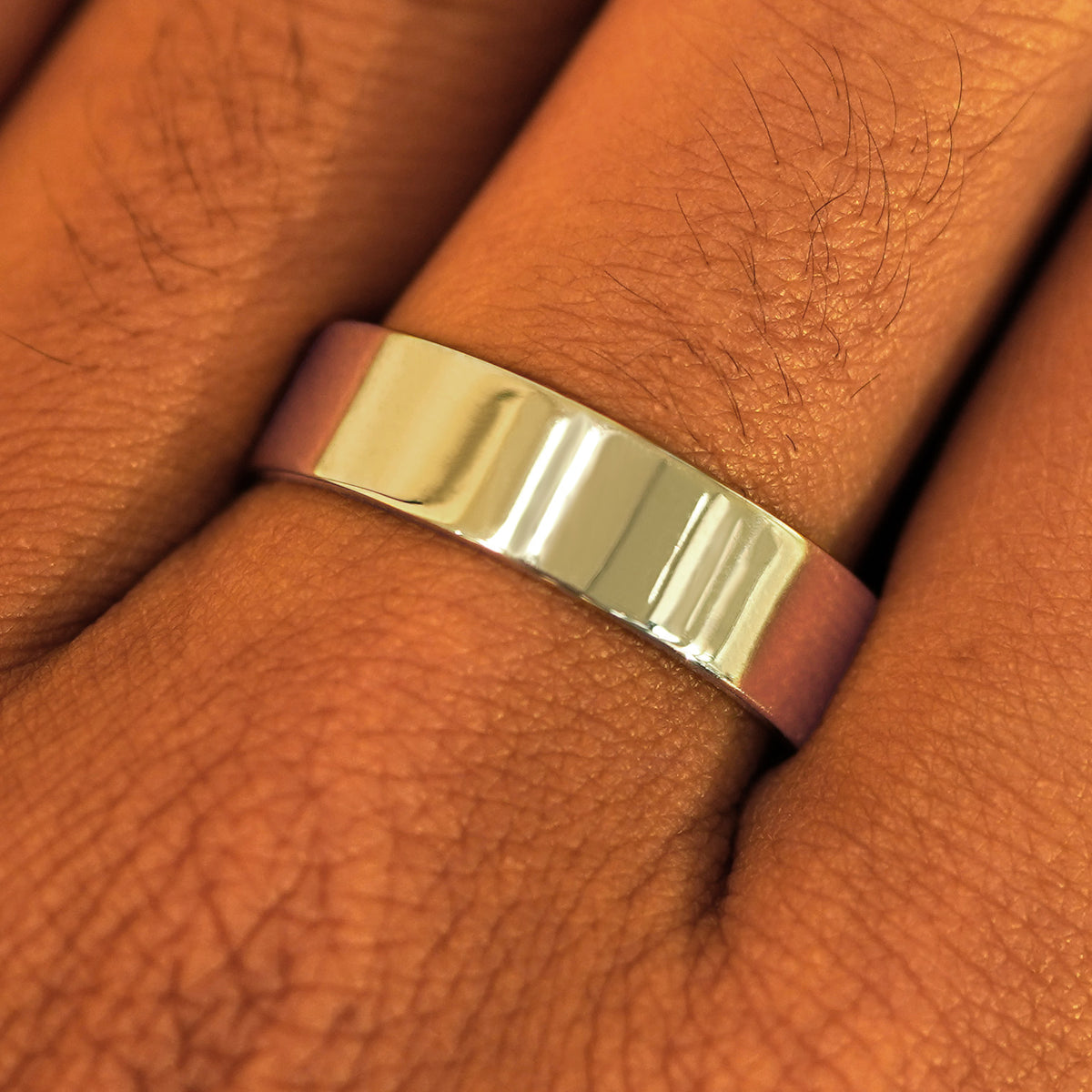 Close up view of a model's fingers wearing a 14k champagne gold Industrial Mirror Band