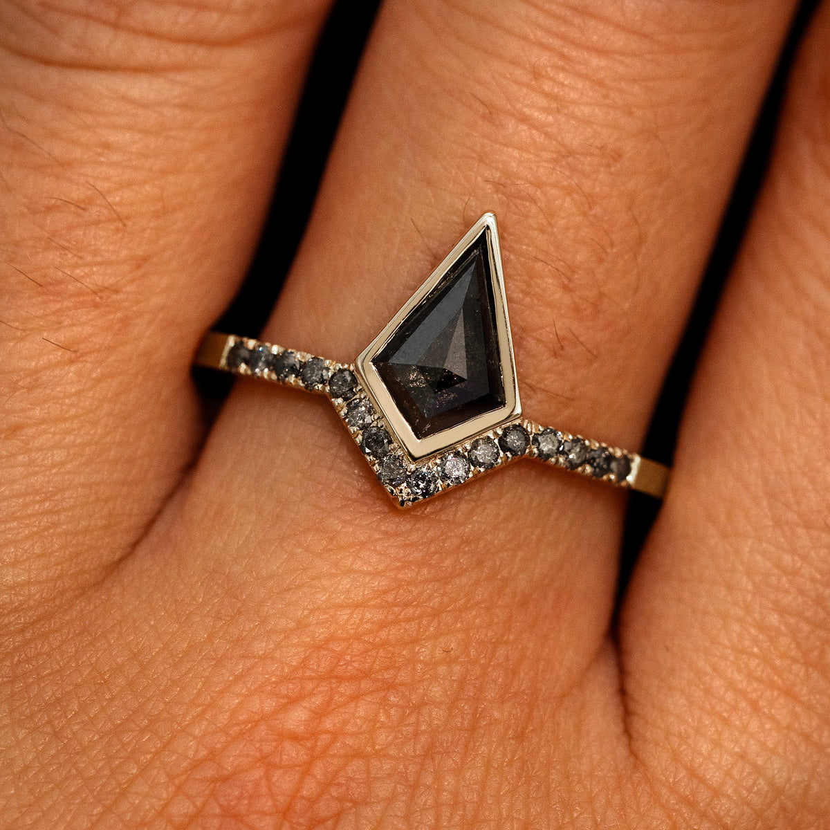 A model's hand wearing a 14k champagne gold Kite Salt and Pepper Diamond Pave Chevron Ring