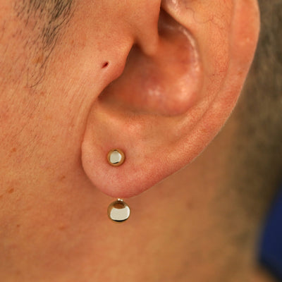 Close up view of a model's ear wearing a 14k champagne gold Large Curved Barbell through a lobe piercing