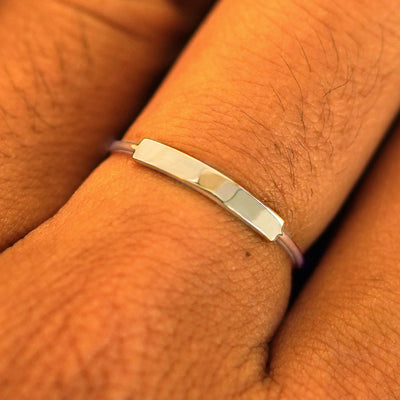 Close up view of a model's fingers wearing a champagne gold Bar Ring