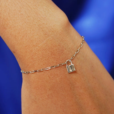 Close up view of a model's wrist wearing a champagne gold Lock Charm on a Butch Bracelet