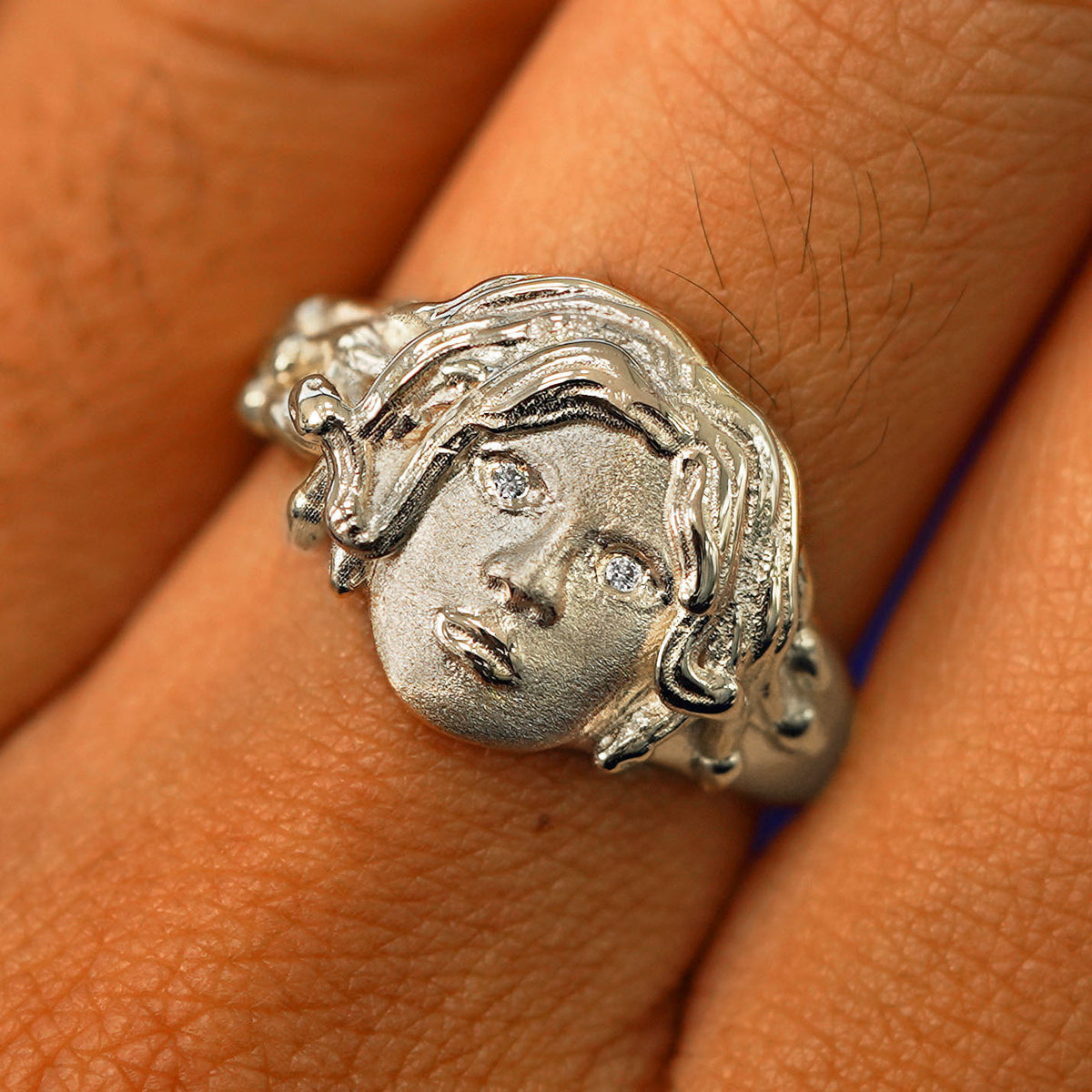 Close up view of a model's fingers wearing a 14k champagne gold Medusa Ring