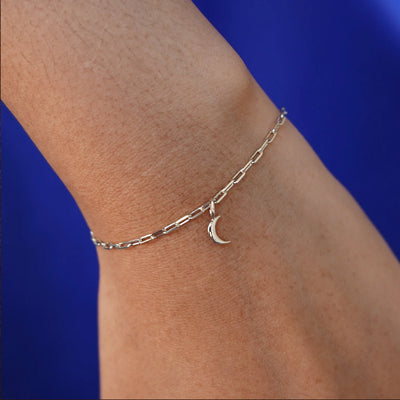 Close up view of a model's wrist wearing a champagne gold Moon Charm on a Butch Chain Bracelet