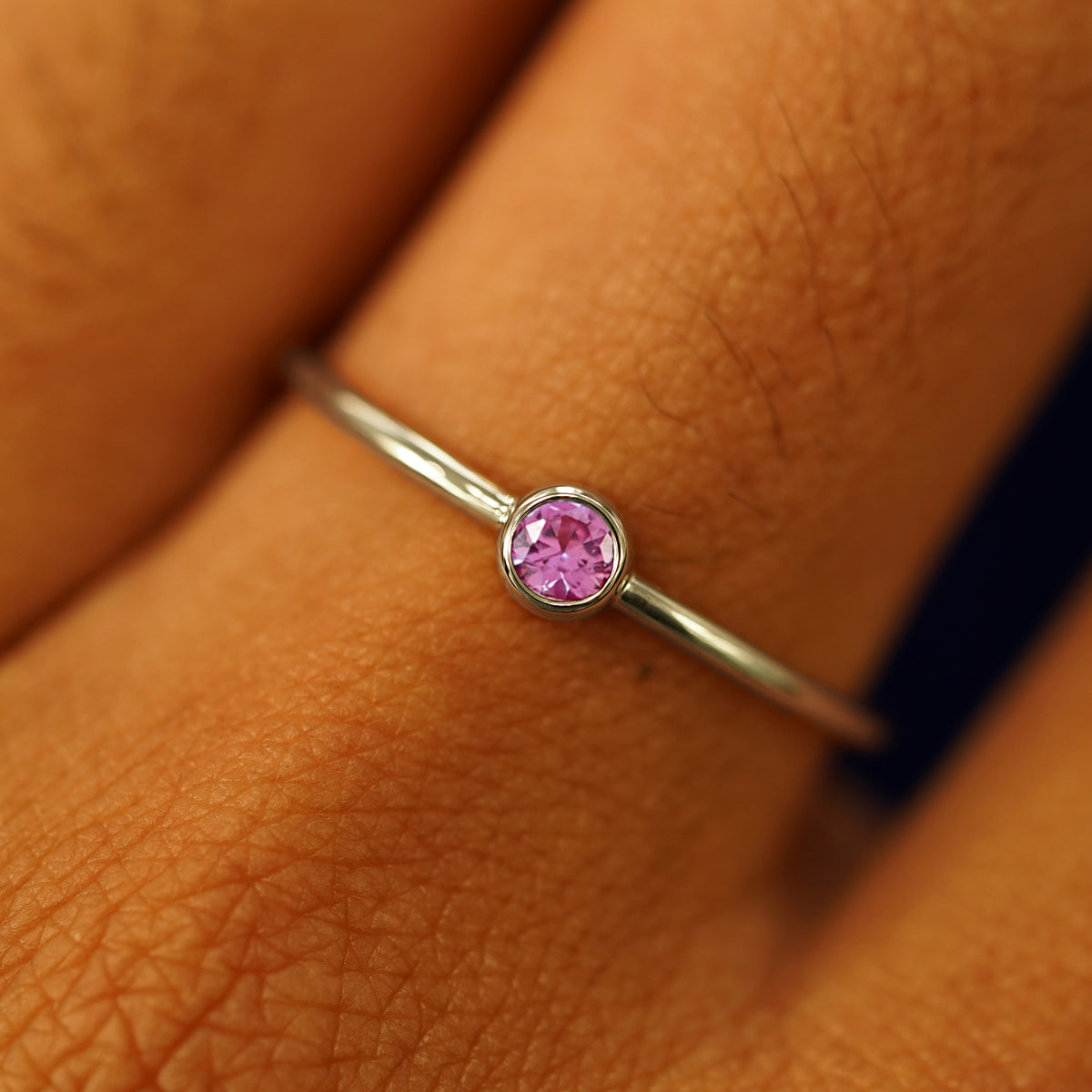 Close up view of a model's fingers wearing a 14k champagne gold Pink Sapphire Ring