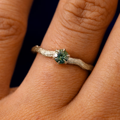 A solid 14k champagne gold Montana Teal Sapphire Waved Branch Ring on a model's finger