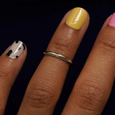 Close up view of a model's hand wearing a champagne gold Single Line Toe Ring as a midi ring