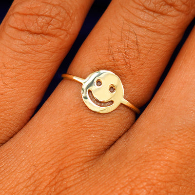 Close up view of a model's fingers wearing a 14k champagne gold Smiley Face Ring