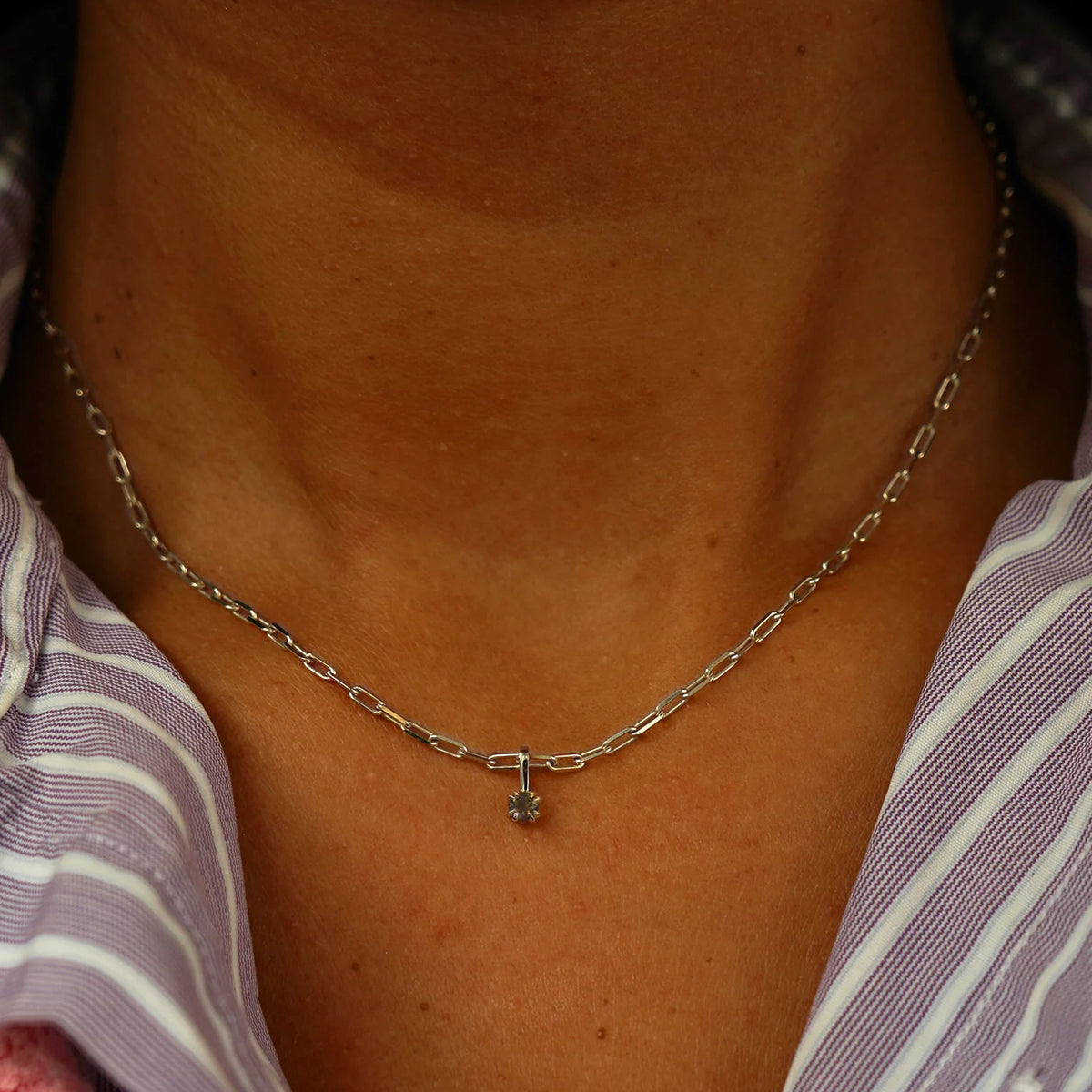 Close up view of a model's neck wearing a champagne gold Smoky Quartz Charm on a Butch Chain
