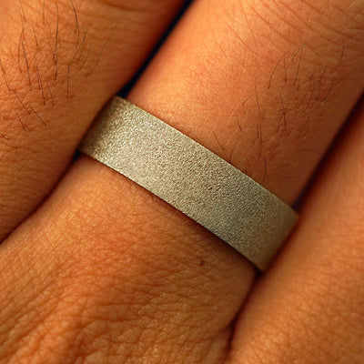 Close up view of a model's fingers wearing a 14k champagne gold Industrial Stardust Band