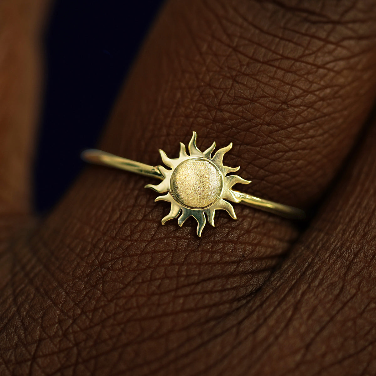 Close up view of a model's fingers wearing a 14k champagne gold Sun Ring