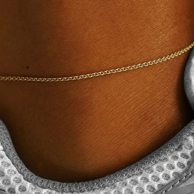 Close up view of a model's ankle wearing a champagne gold Thick Cable Anklet