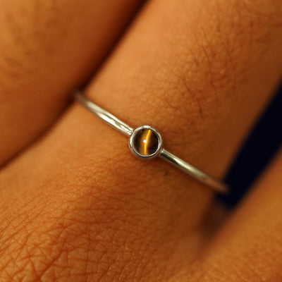 Close up view of a model's fingers wearing a 14k champagne gold Tiger Eye Ring