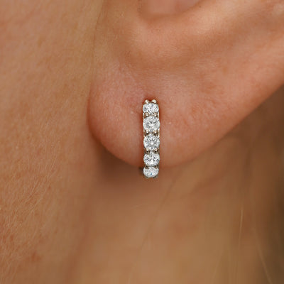 Close up view of a model's ear wearing a champagne gold Mini Lab White Diamond Huggie Hoop