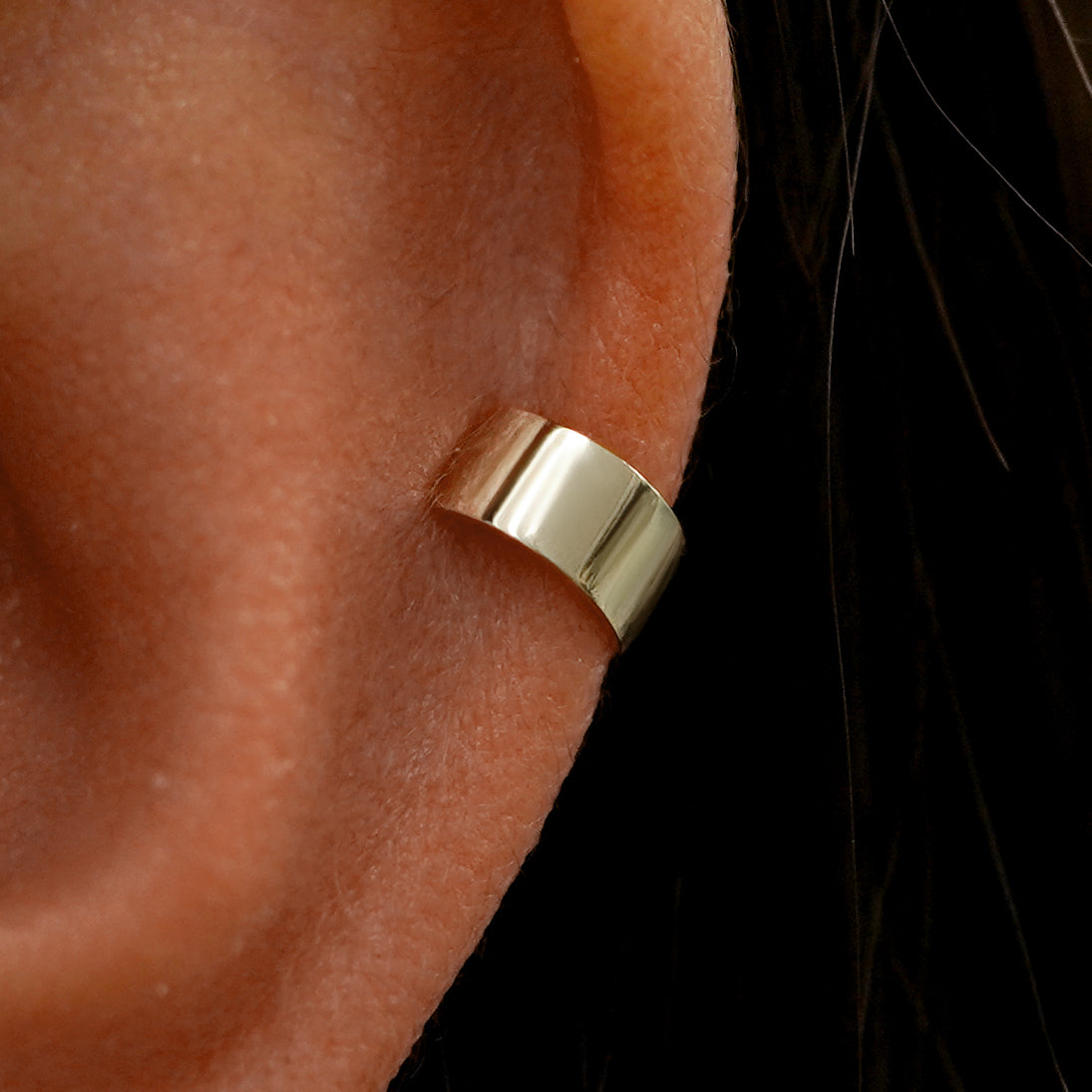 Close up view of a model's ear wearing a champagne gold Wide Cuff