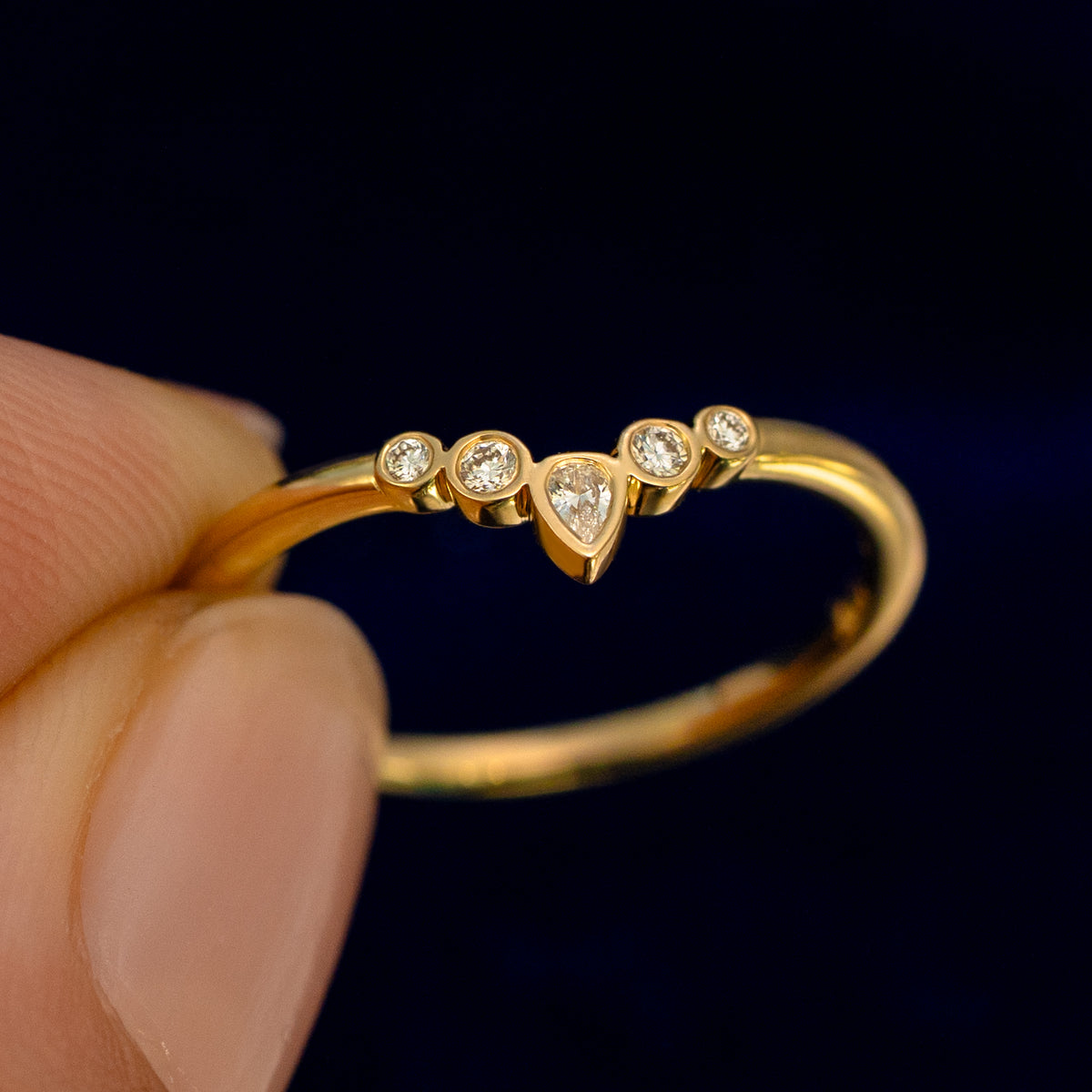 A model holding a Chevron Tiara Diamond Band up to show the details of the design and the inside of the ring