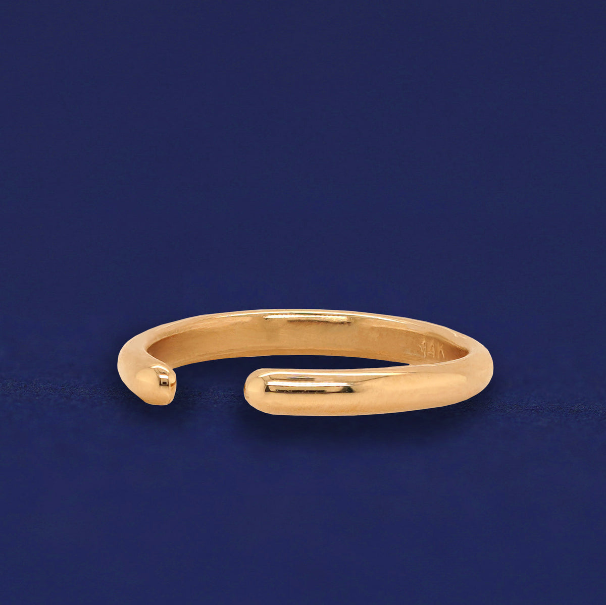 Side view of a yellow gold Single Line Toe Ring to show adjustable opening