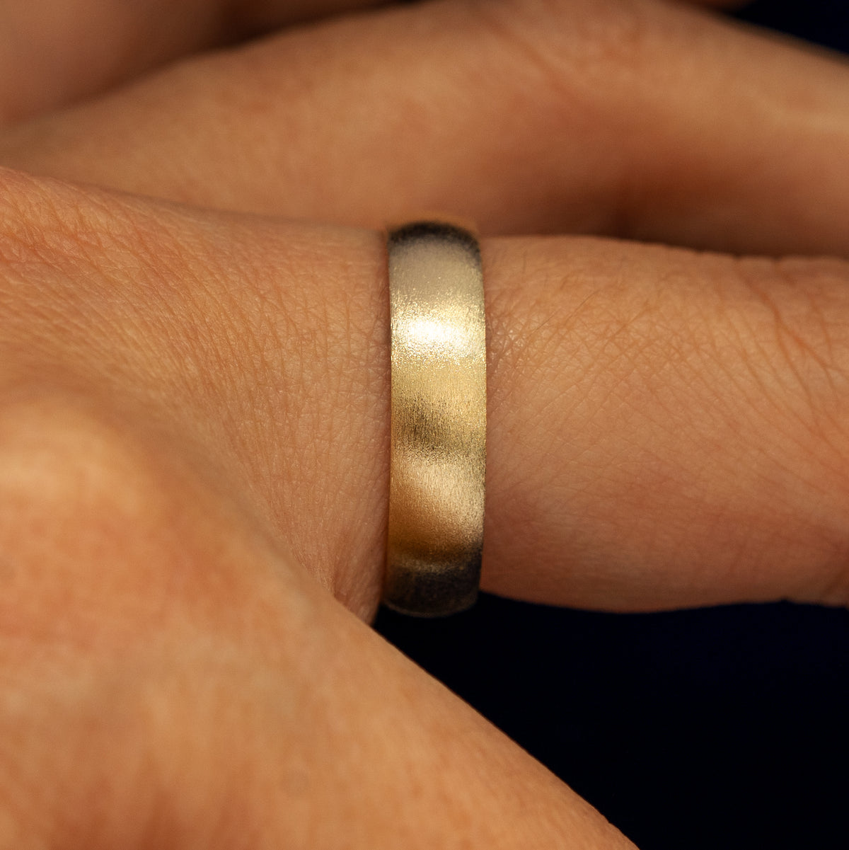 Side view of a Curvy Matte Band on a model's finger