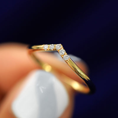 A model holding a Diamond Chevron Band tilted to show the side of the band
