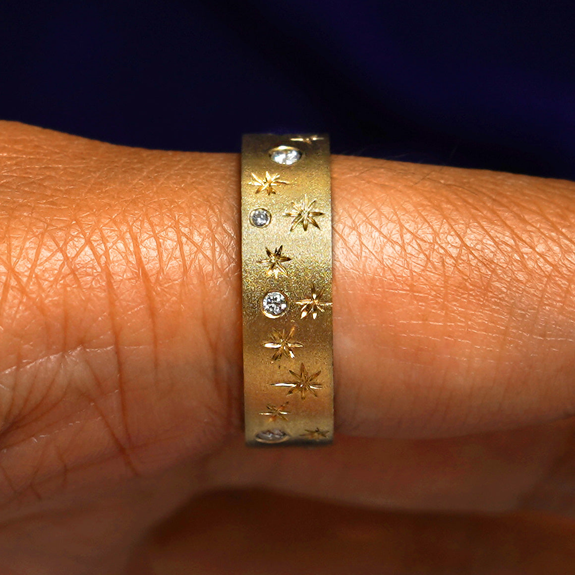 Side view of a Stars and Diamonds Band on a model's finger