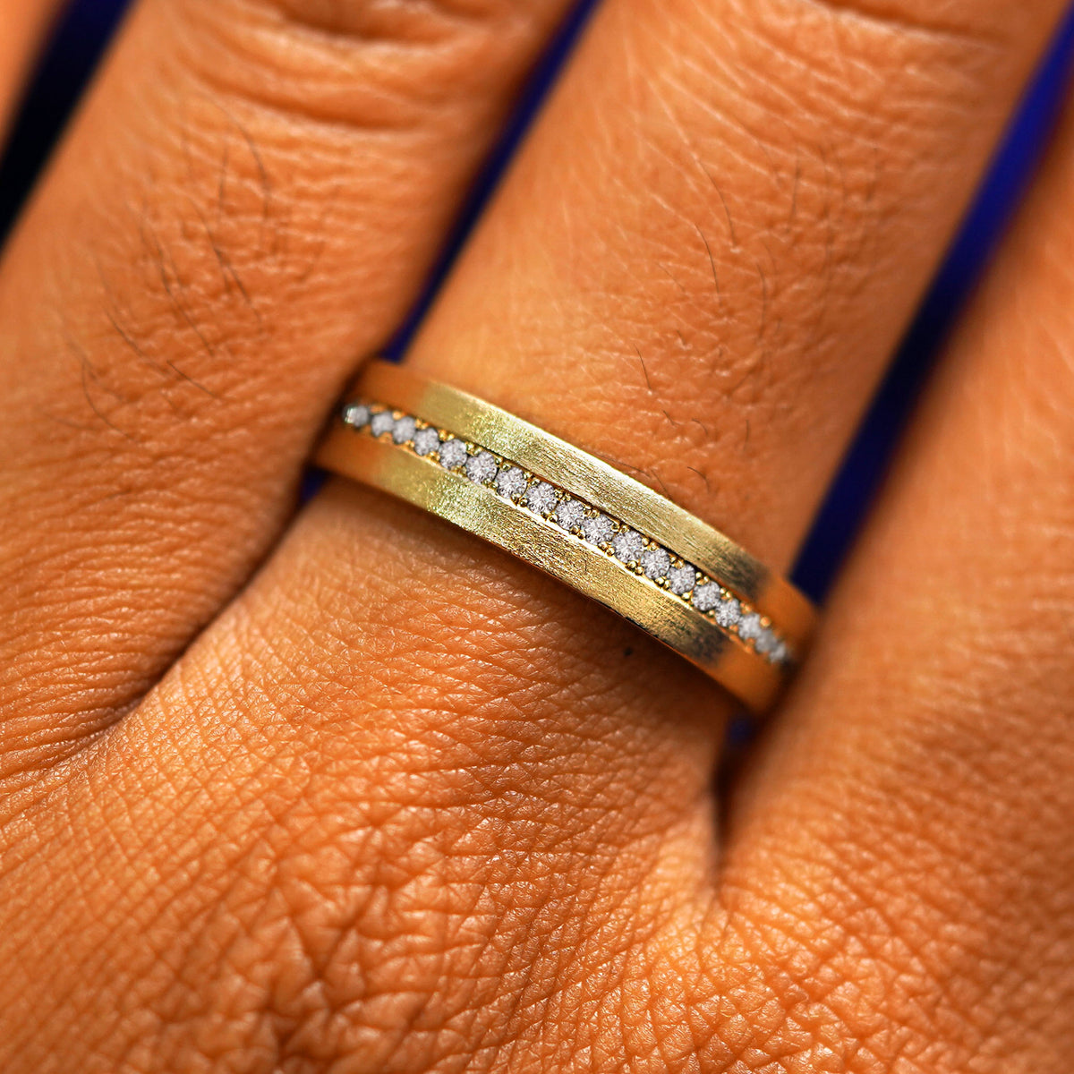 Close up view of a model's fingers wearing a 14k yellow gold Endless Clear Diamond Band