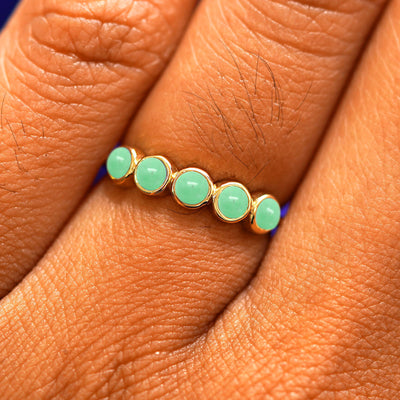 Close up view of a model's hand wearing a yellow gold 5 Gemstones Ring in jade