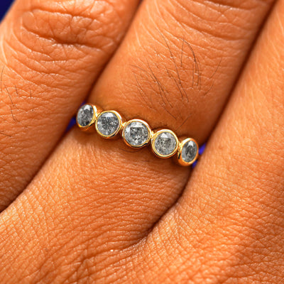 Close up view of a model's fingers wearing a 14k yellow gold Five Diamond Ring with salt and pepper diamonds