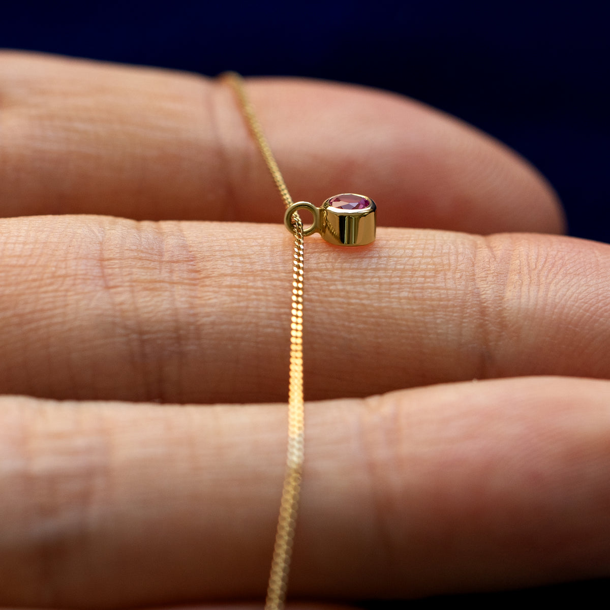 A side view of the gemstone necklace on model's hand
