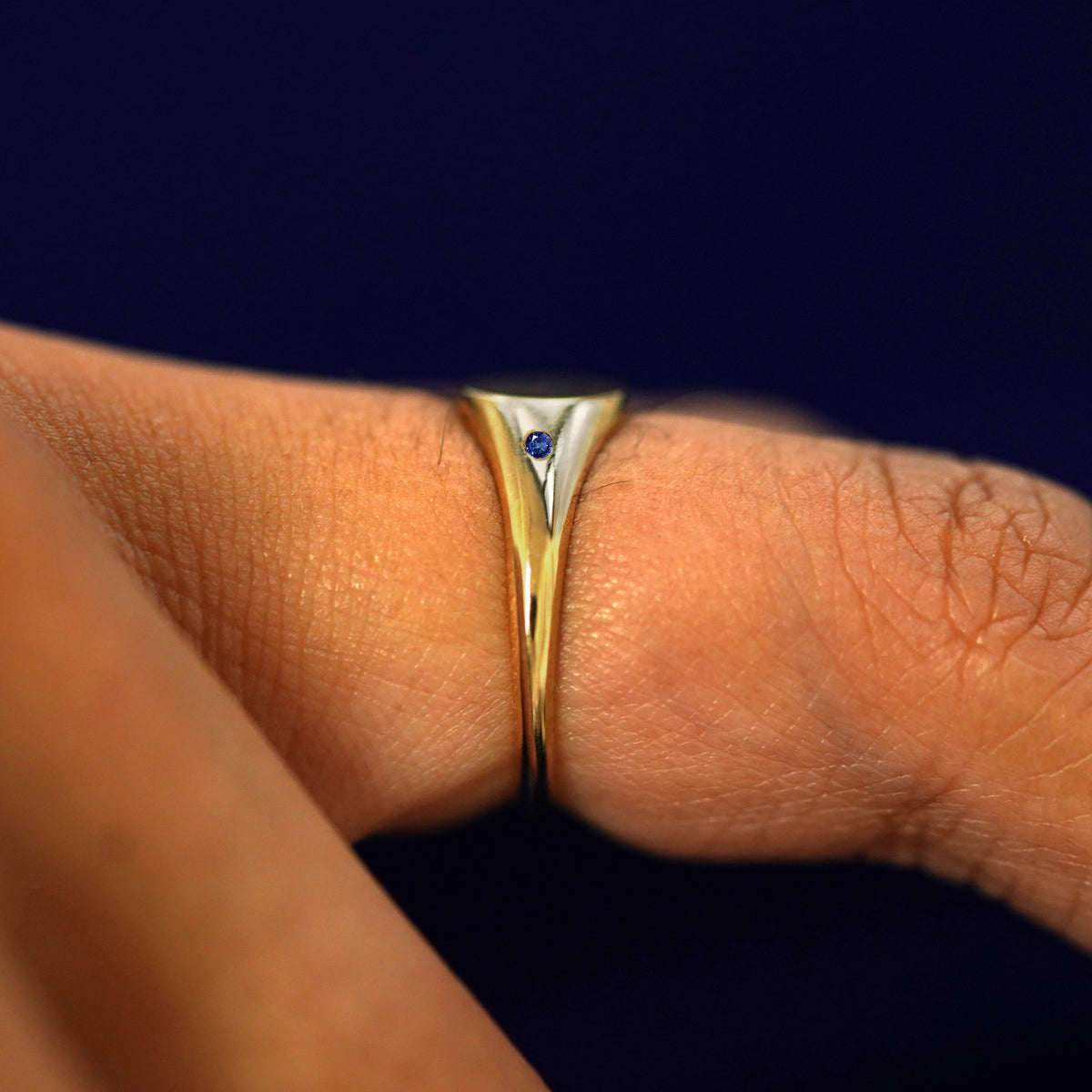 Side view of a sapphire Gemstone Signet Ring on a model's finger