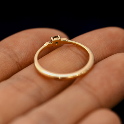 An angled view of a Smoky Quartz Gemstone Two Leaf Ring resting on a model's fingers to show underneath the setting
