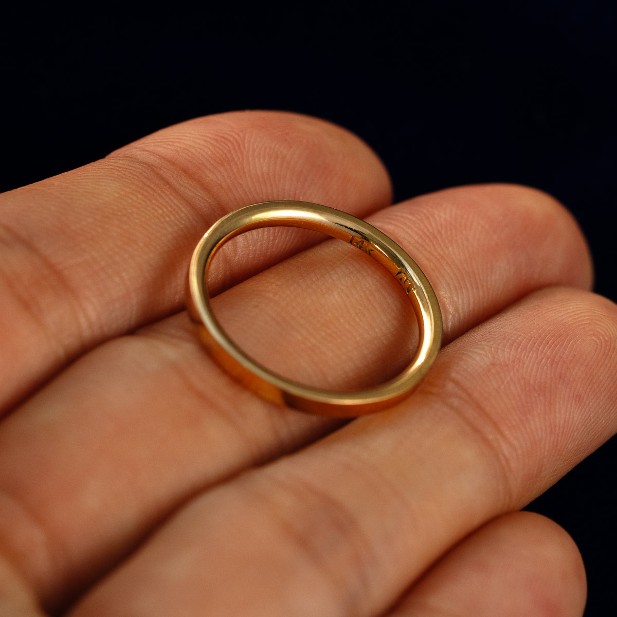 A Flush Set Baguette Diamond Ring in a model's hand showing the inside of the band