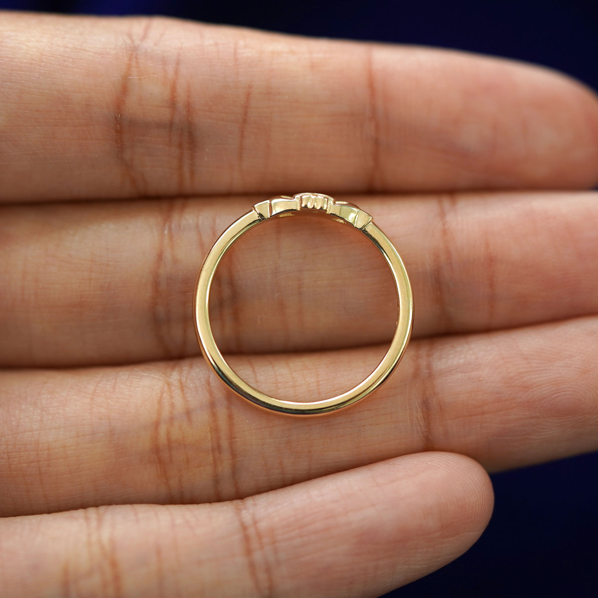 A yellow gold Thin Gemstone Claddagh Ring in a model's hand showing the thickness of the band