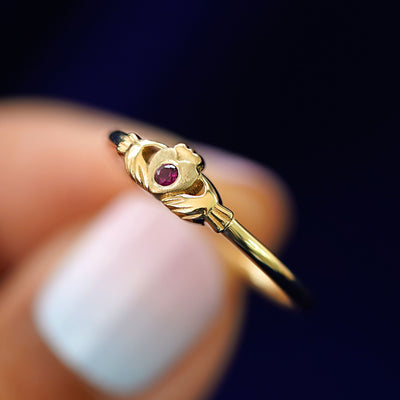 A model holding a Thin Gemstone Claddagh Ring tilted to show the side of the ring