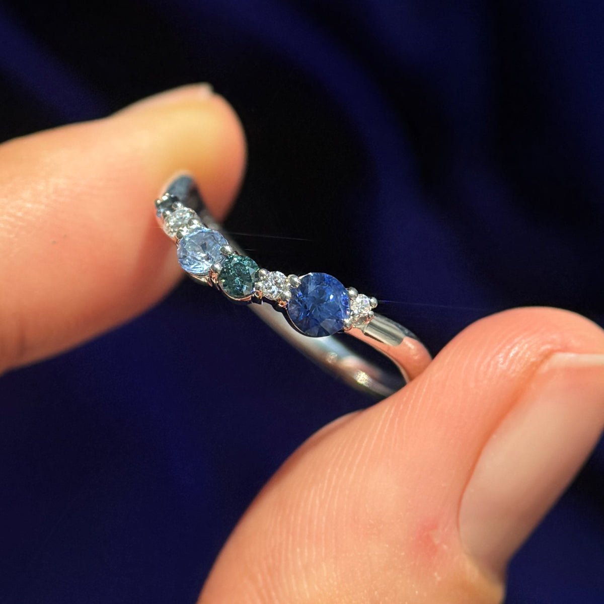 A models holding 14k White Gold Custom Stacking Band with 6pc Gradient of Blue Sapphire