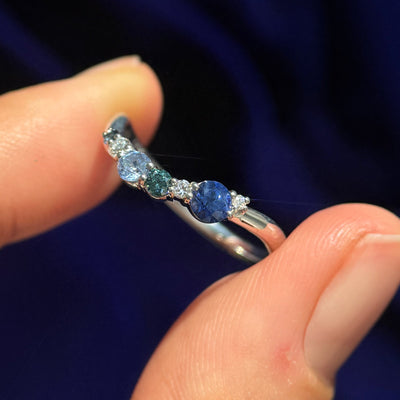 A models holding 14k White Gold Custom Stacking Band with 6pc Gradient of Blue Sapphire