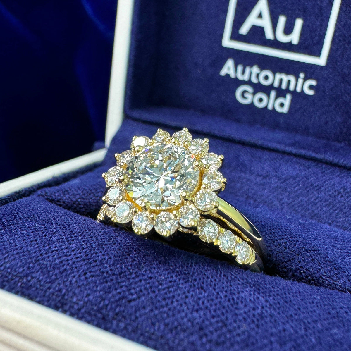 A lab diamond flower ring with petal set lab diamond band in a blue ring box