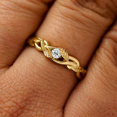 A solid 14k yellow gold lab white diamond leaves and vines ring on a model's finger