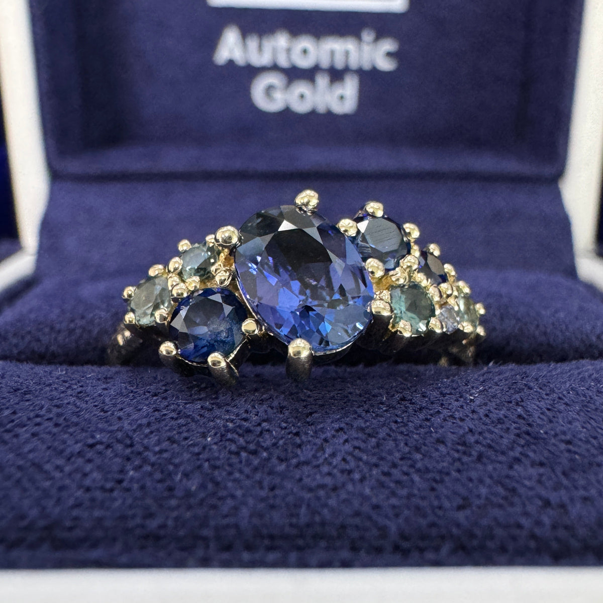 14k Yellow Gold Claw-prongs-set 0.90ct 7x5.1mm Oval Blue Sapphire w/ Round Blue/Purple/Teal Sapphires Cluster on 2mm Curvy Band Custom Ring 