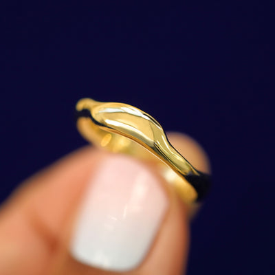 Alternate view of a model holding a Liquid Band tilted to show more unique waves in the band