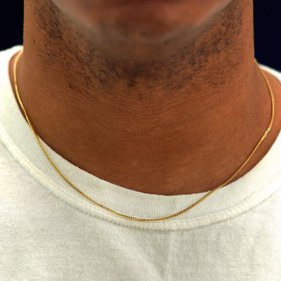 A model's neck wearing a solid yellow gold Mini Miami Chain