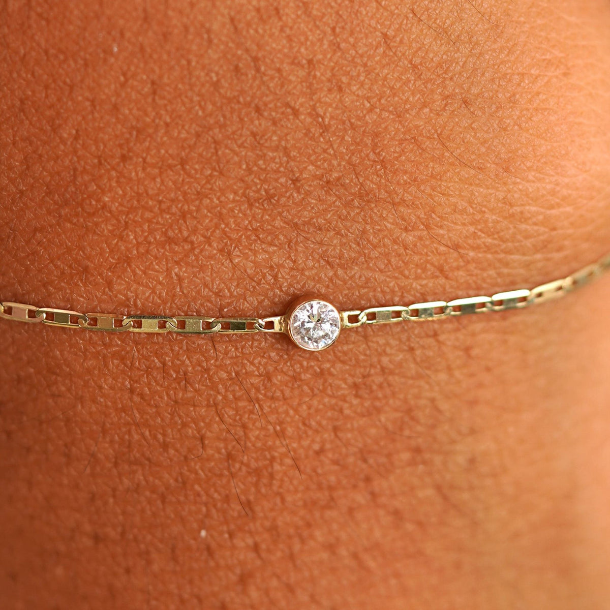 Close up view of a models wrist wearing 14k yellow gold Moissanite Bracelet