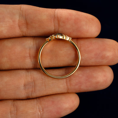 An Oval Salt and Pepper Diamond Heart Prong Ring in a model's hand showing the thickness of the band