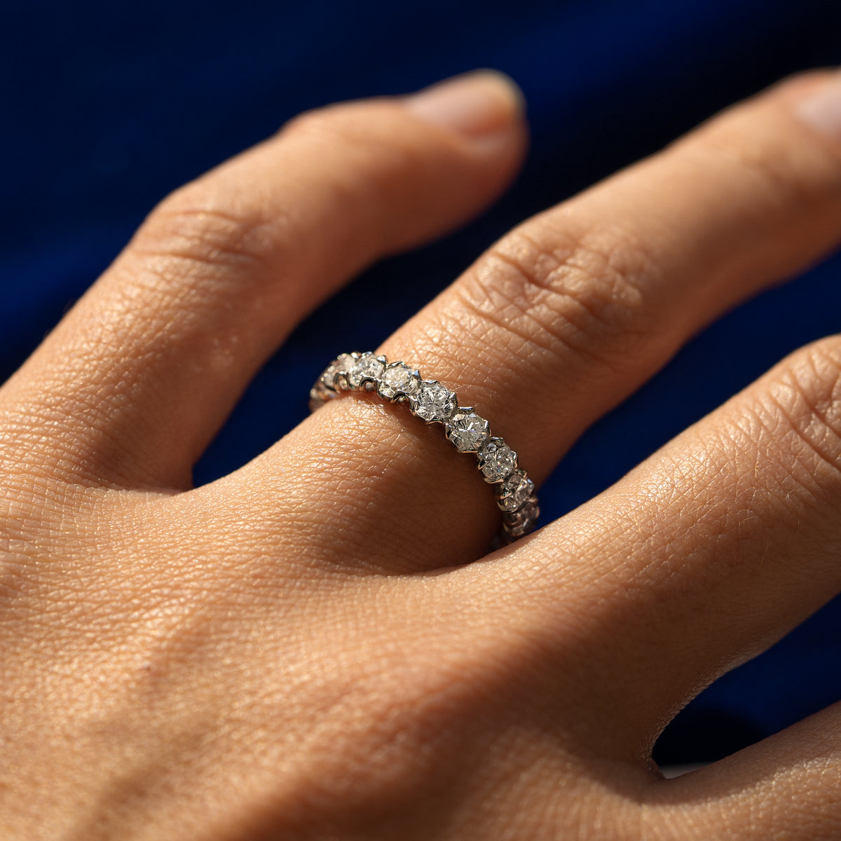 Side view of a Petal Set Diamond Eternity Band on a model's finger