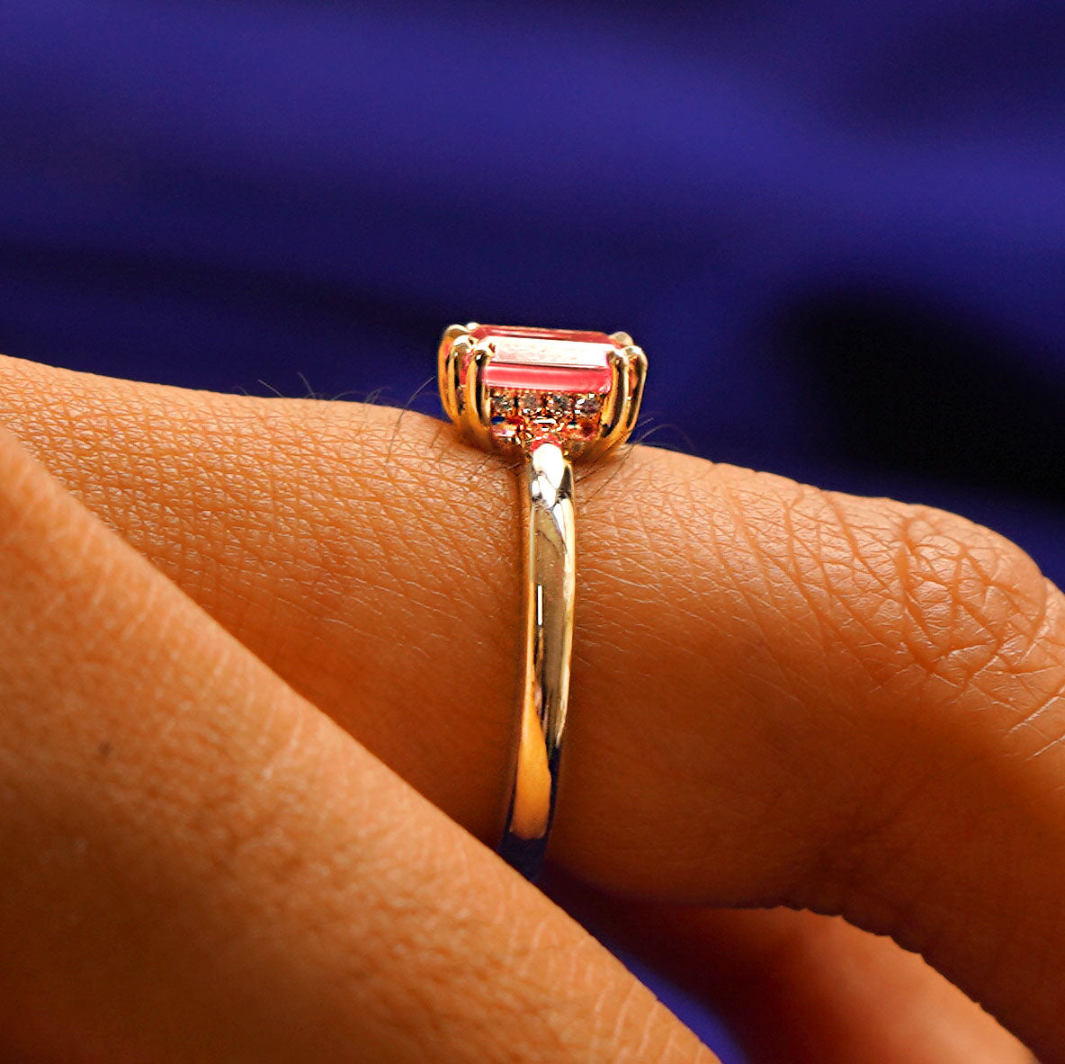 Side view of a pink sapphire Kepeh Ring on a model's finger to show the hidden halo