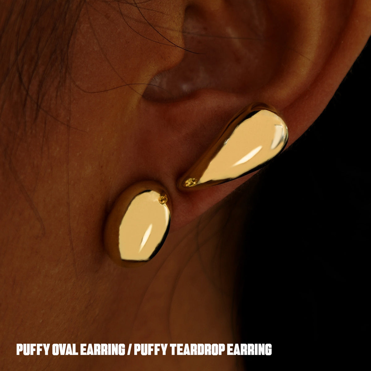 A model's ear with a yellow gold Oval Puffy and Teardrop Puffy Earring worn horizontally on two different lobe piercings
