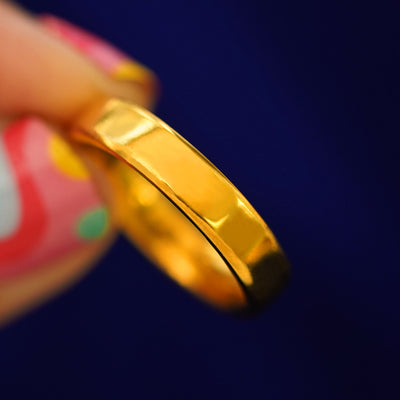 A model holding a 24k Mix Mirror Band tilted to show the side of the band