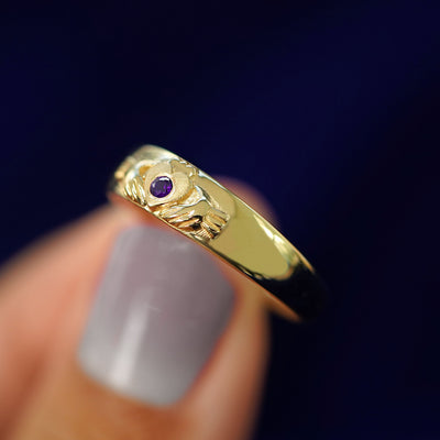 A model holding a Gemstone Claddagh Band tilted to show the side of the Band