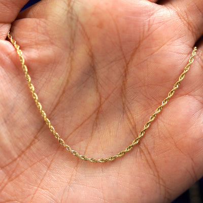 A yellow gold Rope Chain draped on a model's palm