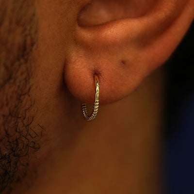 Close up view of a model's ear wearing a Rope Septum as a hoop earring