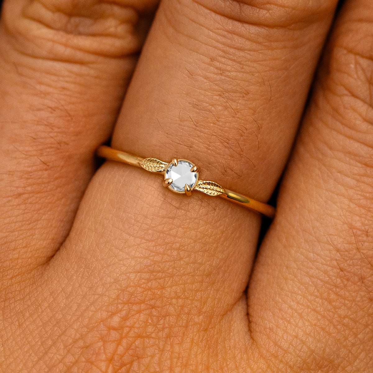 A solid 14k yellow gold Rose Cut Diamond Two Leaf Ring on a model's finger
