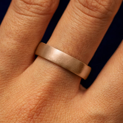 Close up view of a model's fingers wearing a 14k rose gold Mix Matte Band